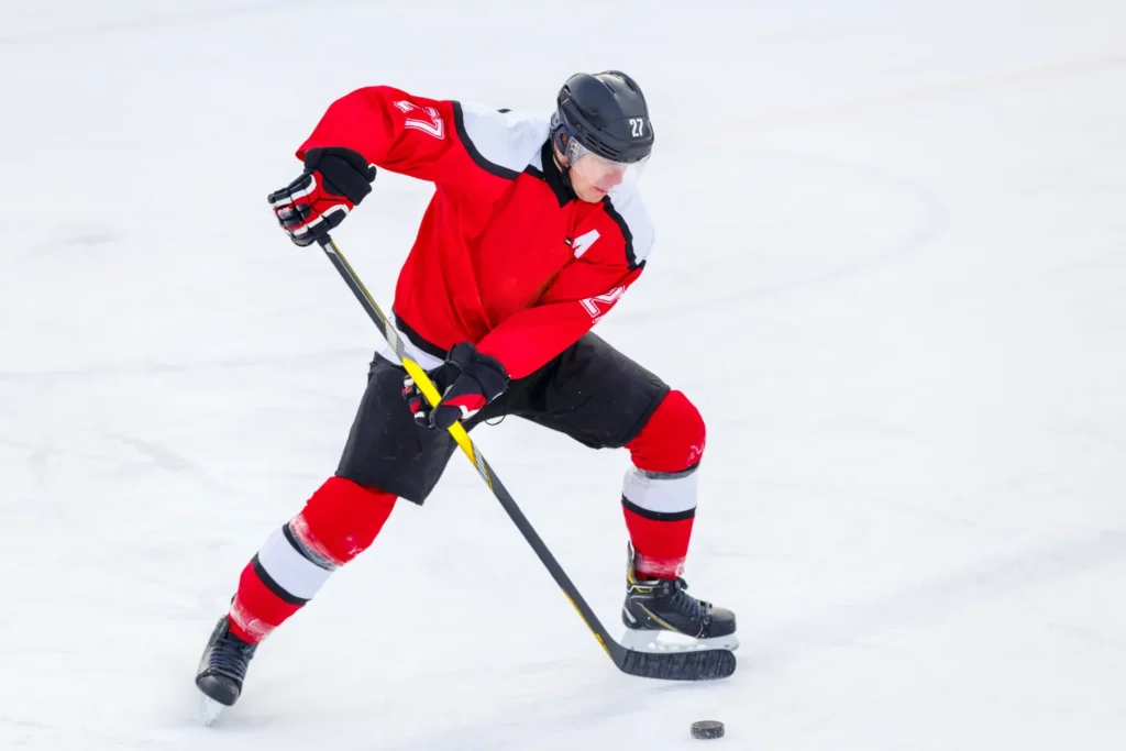 2026 Winter Olympics Ice Hockey Player in Red Jersey Shooting Ice hockey player in red jersey shooting puck during 2026 Winter Olympics ice hockey match