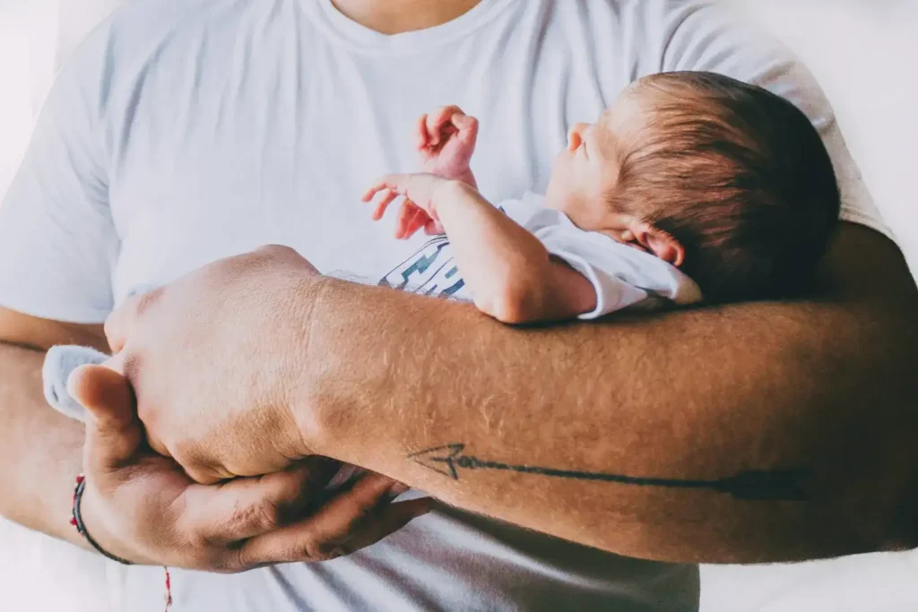 A new father holding his newborn baby, highlighting the often-overlooked new dad depression and anxiety experienced by.