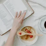 daily habits for personal growth morning routine reading book healthy breakfast and coffee on bed