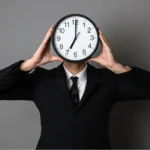 Man holding clock instead of face showing how to manage time effectively for productivity and success