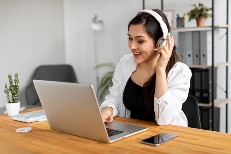 Woman working on laptop with headphones learning how to find remote jobs from home online