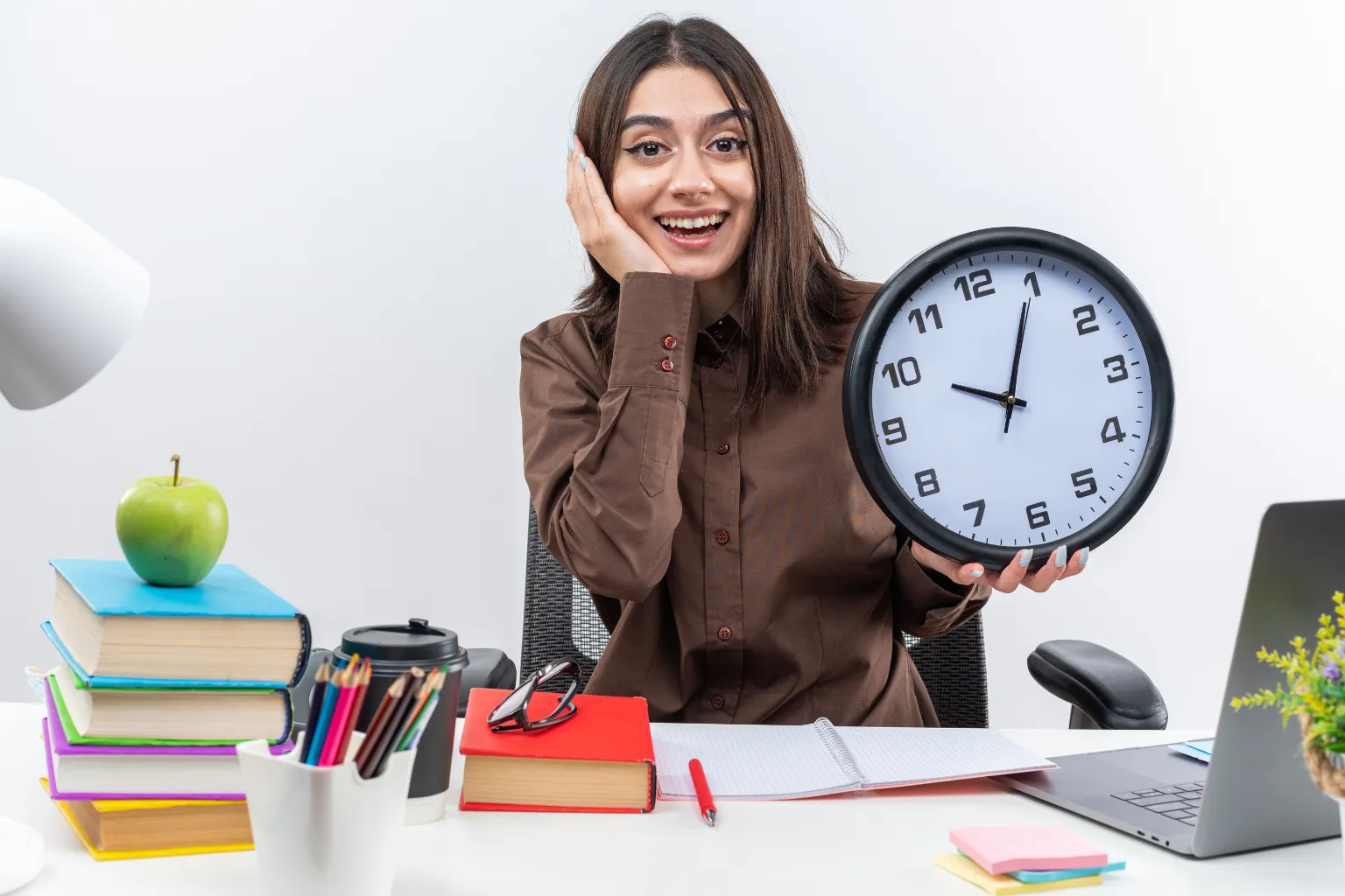 Effective Time Management Tips for Students and Professionals Student holding clock at desk showing effective time management for productivity and study success