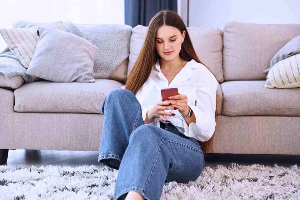 Woman using smartphone at home representing work from home jobs for female without experience and beginner online income ideas